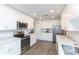 Well-lit kitchen featuring white cabinetry, stainless steel appliances, and stone countertops at 2641 Royal Ridge Dr, Spring Hill, FL 34606