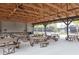 Community picnic pavilion with picnic tables and ceiling fans overlooking tennis and pickleball courts at 2641 Royal Ridge Dr, Spring Hill, FL 34606