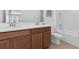 Bathroom featuring double sinks, wooden cabinets and a bath-shower combination for convenience and style at 2830 Dudley Ave, Odessa, FL 33556