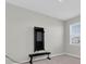 Bright bedroom featuring neutral walls, a window, and a wall-mounted workout station with weights at 2830 Dudley Ave, Odessa, FL 33556