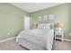 Bright and airy bedroom featuring soft green walls, natural light and cozy decor for relaxation at 2830 Dudley Ave, Odessa, FL 33556