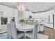 Bright dining area with an elegant chandelier and a full kitchen featuring stainless steel appliances and white cabinets at 2830 Dudley Ave, Odessa, FL 33556