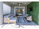 Covered patio with comfortable seating area, television, and sliding doors to the pool at 2830 Dudley Ave, Odessa, FL 33556
