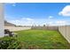 Large, well-maintained backyard with green lawn and partial fencing at 30845 Penny Surf Loop, Wesley Chapel, FL 33545
