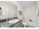 Bright bathroom featuring a tub-shower combo, granite countertops, and modern fixtures at 30845 Penny Surf Loop, Wesley Chapel, FL 33545