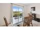 Dining area with a glass table, wood chairs, and a sliding glass door to the backyard at 30845 Penny Surf Loop, Wesley Chapel, FL 33545