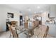 Dining room open to kitchen and living area featuring a glass table and wood chairs at 30845 Penny Surf Loop, Wesley Chapel, FL 33545