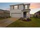 Charming two-story home featuring a well-manicured lawn, neutral paint, and attached two-car garage at 30845 Penny Surf Loop, Wesley Chapel, FL 33545