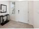 Clean foyer features neutral tiles, a charming mirror, a small table, and a modern front door at 30845 Penny Surf Loop, Wesley Chapel, FL 33545