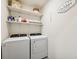 Convenient laundry room with modern appliances and open shelving at 30845 Penny Surf Loop, Wesley Chapel, FL 33545
