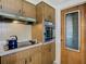 Kitchen with wood cabinets, black stovetop, and oven with a window-paneled door at 3632 Pensdale Dr, New Port Richey, FL 34652