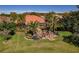 Aerial view of the home, showcasing the backyard, patio, and surrounding lush tropical landscaping at 370 Tall Oak Trl, Tarpon Springs, FL 34688