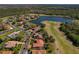 An aerial view shows a home near a golf course and lake in a residential neighborhood at 370 Tall Oak Trl, Tarpon Springs, FL 34688