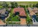 Aerial shot of home with manicured lawn, brick driveway, mature landscaping, and tile roof at 370 Tall Oak Trl, Tarpon Springs, FL 34688