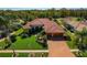 Beautiful single-story home featuring well-manicured lawn, mature landscaping, brick driveway and terra cotta tile roof at 370 Tall Oak Trl, Tarpon Springs, FL 34688