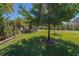 Expansive backyard with mature trees, lush lawn and landscaping, plus a view of the golf course at 370 Tall Oak Trl, Tarpon Springs, FL 34688