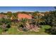Spacious backyard with a brick patio, screened in porch, mature landscaping, and a flagpole at 370 Tall Oak Trl, Tarpon Springs, FL 34688