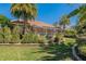 Screened-in lanai on house with manicured landscaping, raised garden beds, and palms at 370 Tall Oak Trl, Tarpon Springs, FL 34688