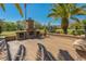Comfortable outdoor brick patio with a fireplace and seating among lush tropical landscaping at 370 Tall Oak Trl, Tarpon Springs, FL 34688