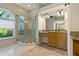 Bright bathroom showcasing a glass shower, vanity with granite countertop, and large arched window at 370 Tall Oak Trl, Tarpon Springs, FL 34688