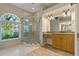 Bright bathroom showcasing a glass shower, vanity with granite countertop, and large arched window at 370 Tall Oak Trl, Tarpon Springs, FL 34688