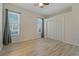 Bright bedroom features wood-look flooring, natural light from two windows and a ceiling fan at 370 Tall Oak Trl, Tarpon Springs, FL 34688