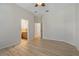 Neutral bedroom with wood-look floors and open doorway to bathroom at 370 Tall Oak Trl, Tarpon Springs, FL 34688