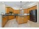 Well-appointed kitchen features a central island, wood cabinets, and stainless steel appliances at 370 Tall Oak Trl, Tarpon Springs, FL 34688