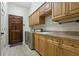 Large laundry room with wood cabinets, countertop space, utility sink, and wood door at 370 Tall Oak Trl, Tarpon Springs, FL 34688