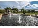 Water feature with multiple fountains, palm trees, and meticulously maintained landscaping at 370 Tall Oak Trl, Tarpon Springs, FL 34688