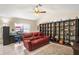 Bright living room features a red leather sofa, open shelving, and neutral tile floors at 4615 Elwood Rd, Spring Hill, FL 34609