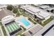 Aerial view of condo community featuring a swimming pool, shuffleboard, parking, and well-maintained landscaping at 4712 Marine Pkwy # 104, New Port Richey, FL 34652
