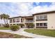 Exterior view of condo featuring covered balcony, walkway, and manicured landscaping around the building at 4712 Marine Pkwy # 104, New Port Richey, FL 34652