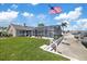 Waterfront backyard featuring a grassy area, screened pool, dock, and an American flag at 5000 Galleon Ct, New Port Richey, FL 34652