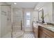 Updated bathroom with glass-enclosed shower and dual vanities with granite countertops at 5000 Galleon Ct, New Port Richey, FL 34652