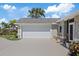 Attached two-car garage with a paved driveway and lush landscaping, providing convenience and curb appeal at 5000 Galleon Ct, New Port Richey, FL 34652