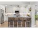 Kitchen with stainless steel appliances, barstool seating and bright lighting, adjacent to a living space filled with greenery at 5000 Galleon Ct, New Port Richey, FL 34652