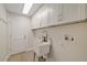 Clean laundry room boasts white cabinetry, a utility sink, and bright lighting at 5000 Galleon Ct, New Port Richey, FL 34652