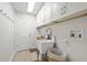 Efficient laundry room features ample white cabinets, a utility sink, and a convenient laundry basket at 5000 Galleon Ct, New Port Richey, FL 34652