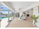 Open-concept living room with a fireplace, waterfront views, access to the pool, and comfortable seating at 5000 Galleon Ct, New Port Richey, FL 34652