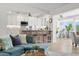 Inviting living room with open floor plan to modern kitchen featuring white cabinets, barstool seating, and stainless steel appliances at 5000 Galleon Ct, New Port Richey, FL 34652