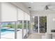 Light-filled living room featuring tile floors, waterfront views, and access to the pool and outdoor patio at 5000 Galleon Ct, New Port Richey, FL 34652