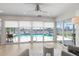 Bright living room with plush seating, tile floors, and expansive views of the pool and waterfront through large windows at 5000 Galleon Ct, New Port Richey, FL 34652