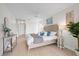 Airy main bedroom featuring wood-look floors, a queen bed with decorative pillows, and ample natural light at 5000 Galleon Ct, New Port Richey, FL 34652