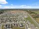 Wide aerial shot displays a residential area's layout with homes, lawns, and the surrounding environment under a sunny sky at 5388 Fez Ct, Brooksville, FL 34602
