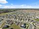 Expansive aerial view of a new residential community featuring well-maintained lawns and modern home designs under a clear blue sky at 5388 Fez Ct, Brooksville, FL 34602