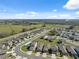 An aerial view of a modern residential community, set against a backdrop of trees and highway at 5388 Fez Ct, Brooksville, FL 34602