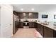 Well-lit kitchen features granite countertops, stainless steel appliances, and dark wood cabinets at 5388 Fez Ct, Brooksville, FL 34602