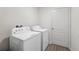 Well-lit laundry room with a washer and dryer set, featuring a neutral color scheme at 5388 Fez Ct, Brooksville, FL 34602