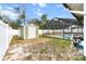 Fenced-in backyard featuring a green shed and a screened-in pool, combining practicality with recreational amenities at 5441 Alderwood St, Spring Hill, FL 34606